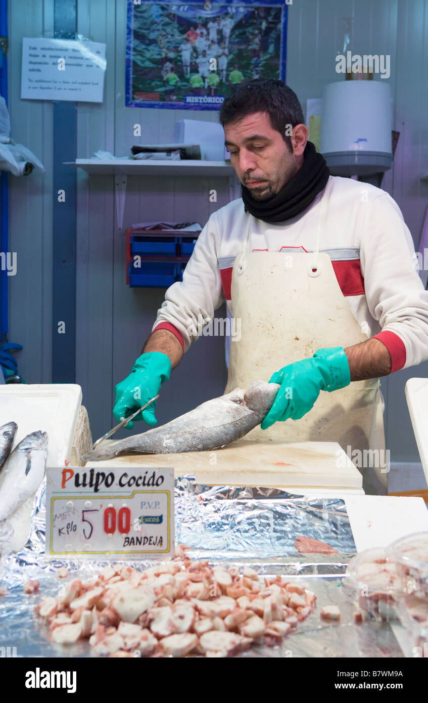 L'uomo pulizia del pesce in Malaga mercato alimentare di Spagna Foto Stock