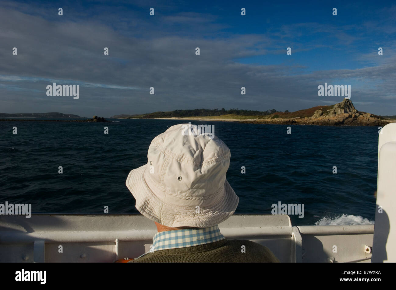 Un passeggero maschio indossa una bianca cappello per il sole sul bordo di una gita in barca intorno alle isole di Scilly. La Cornovaglia. In Inghilterra. Regno Unito Foto Stock