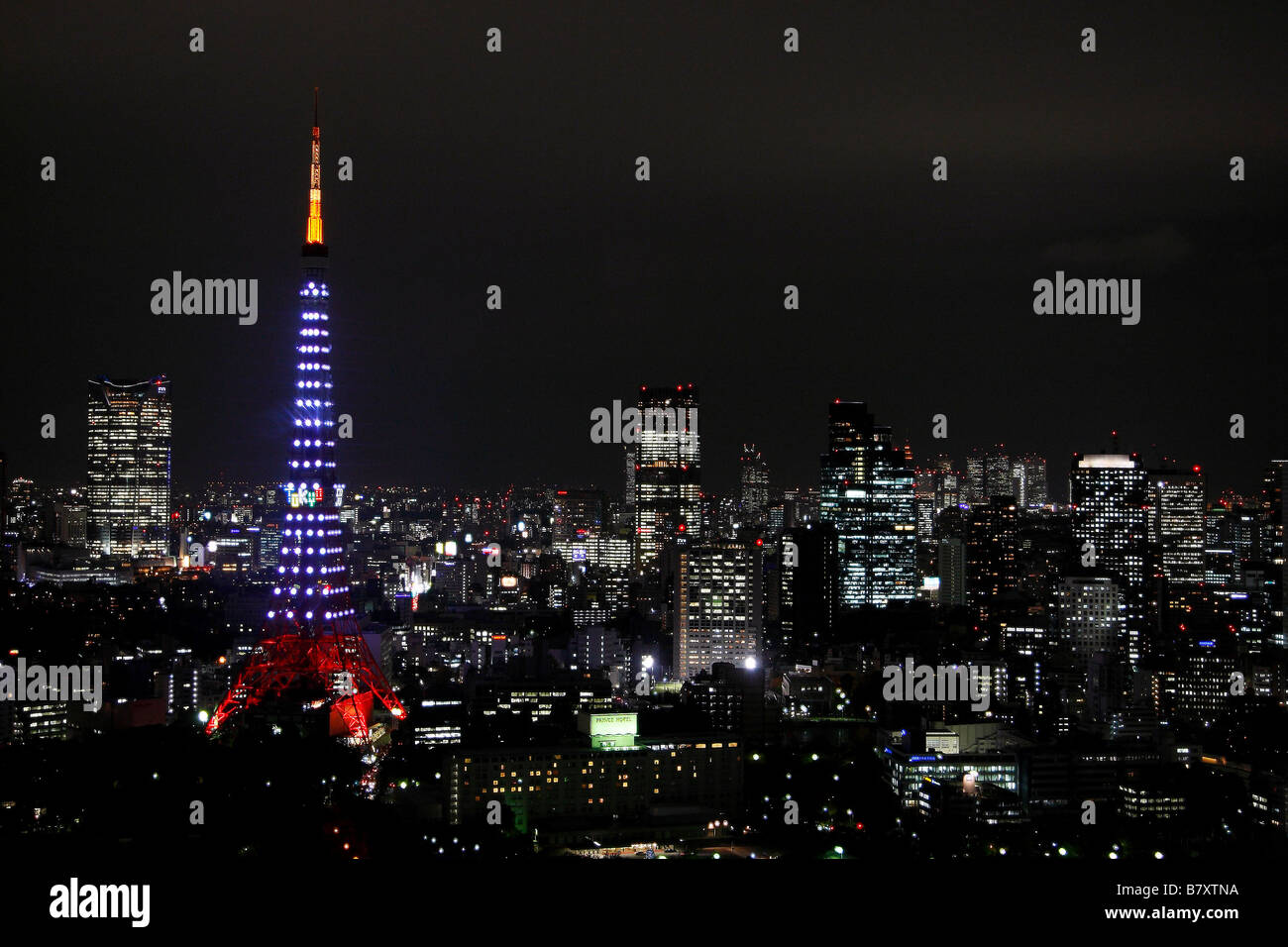 Contro lo sfondo di Tokyo s grattacieli e il cielo di notte la torre di Tokyo è illuminata da 180 Landmark luci su 1 Dicembre 2008 in occasione del cinquantesimo anniversario della Tokyo s landmark 333 metro di altezza della torre di comunicazione aperta per la prima volta al pubblico il 23 dicembre 1958 a seguito di una 14 mese la costruzione in midtown Foto di AFLO 1090 Foto Stock