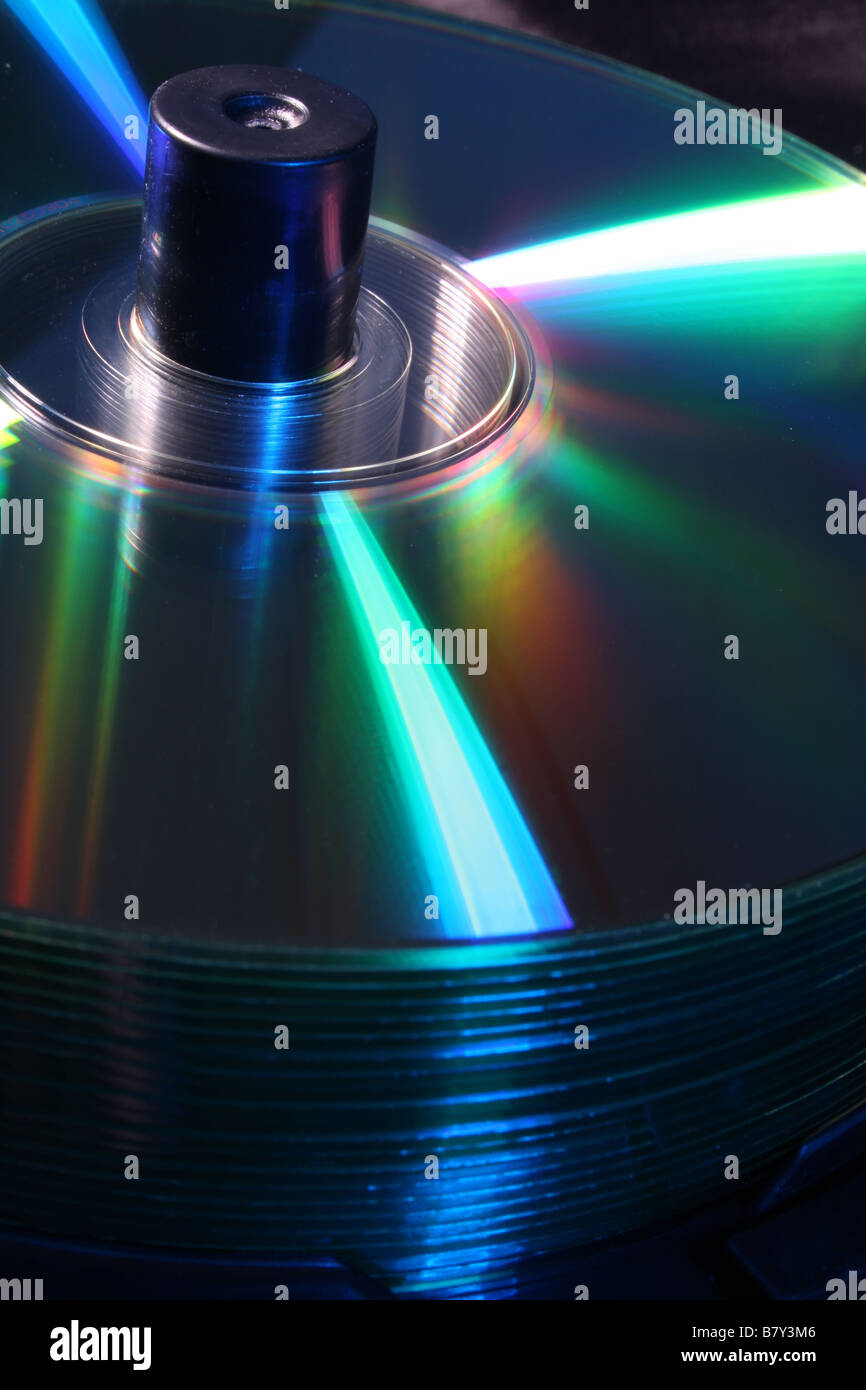 Pila di CD su un mandrino illuminato blu con illuminazione colorata Foto Stock
