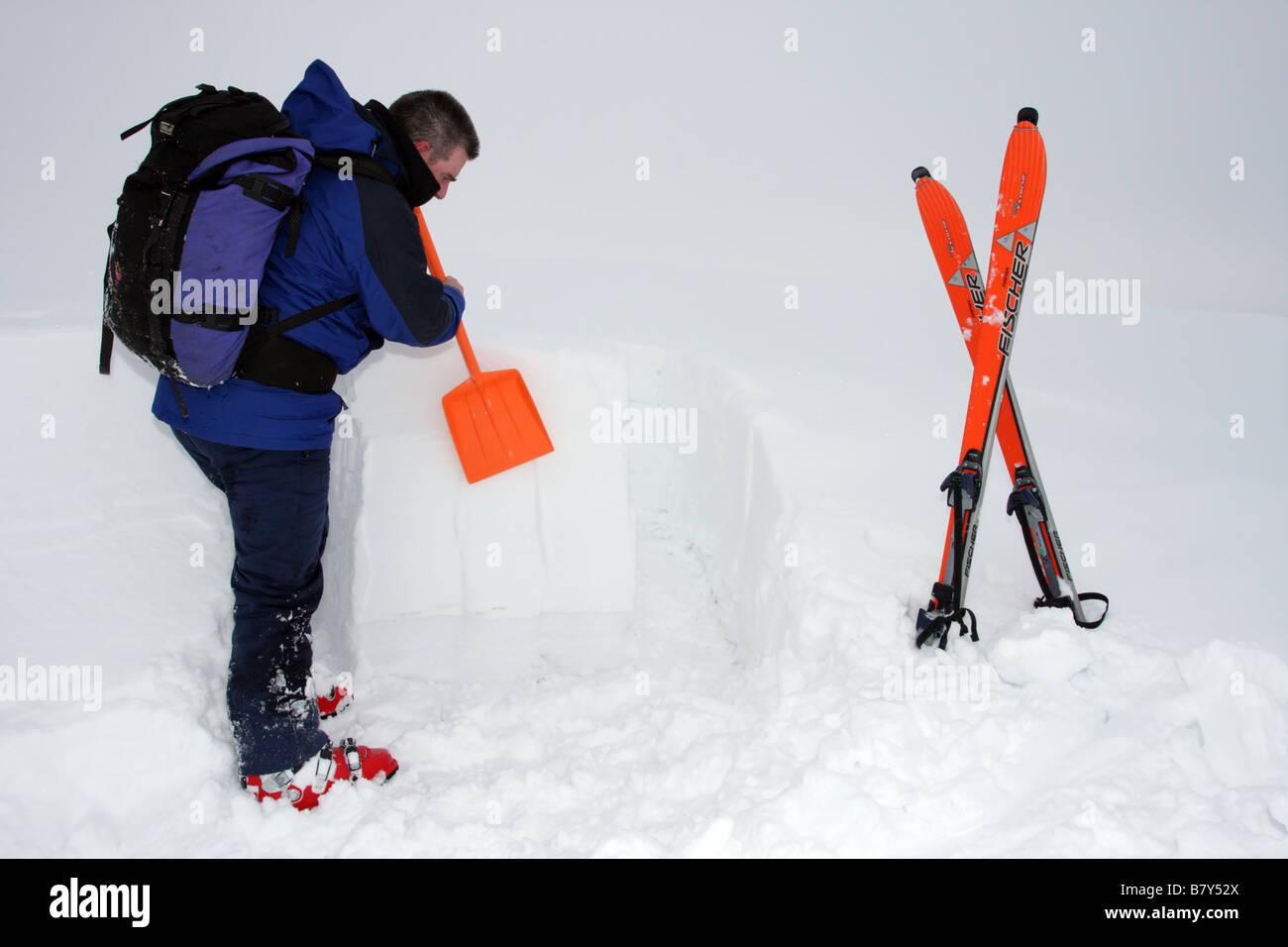 Sciatore lo scavo di un Snowpit al fine di valutare il pericolo di valanghe, Regno Unito Foto Stock