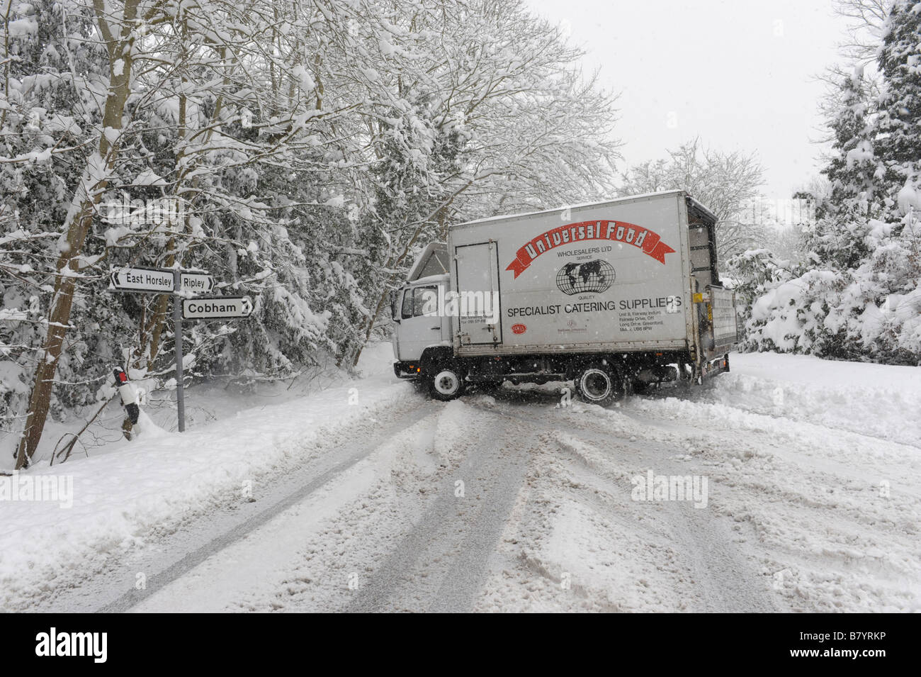 Consegna pattini camion sulla neve e blocca la strada di un paese Foto Stock