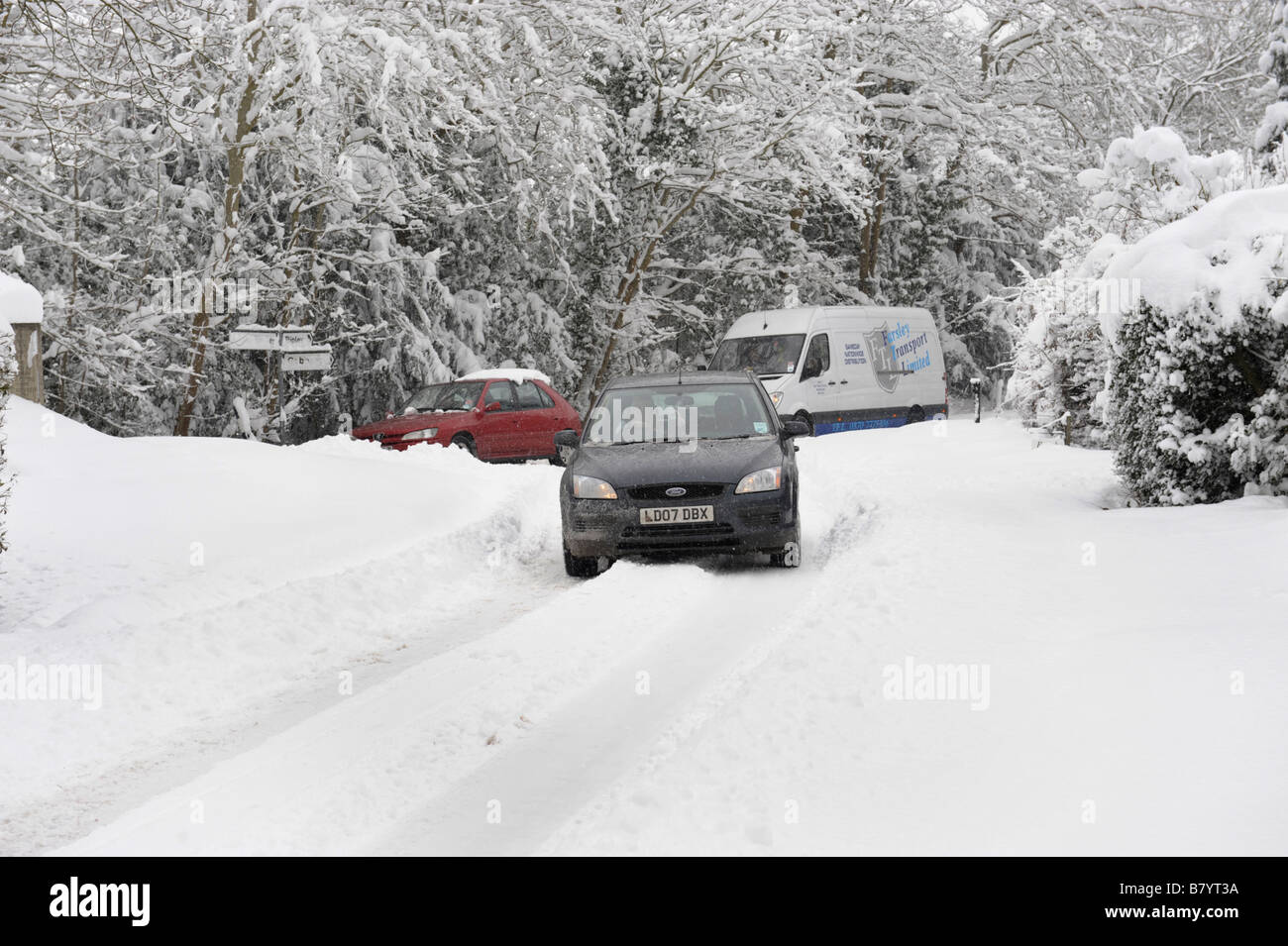 Auto negoziando la neve sulla strada di un paese Foto Stock