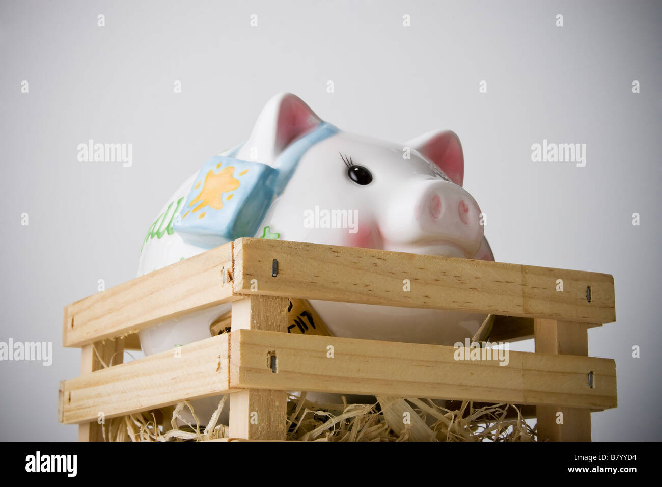 Basso angolo di visione verticale di piggybank all'interno di una gabbia in legno Foto Stock