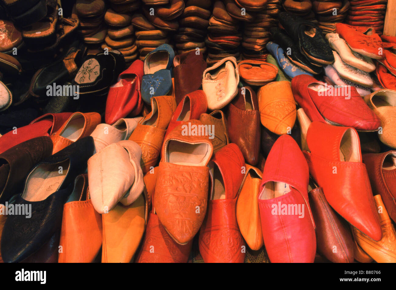 Pile di pelli backless pantofola scarpe, o babouches, in vendita su uno stallo nella medina di Fes el-Bali, Fez, in Marocco. Foto Stock