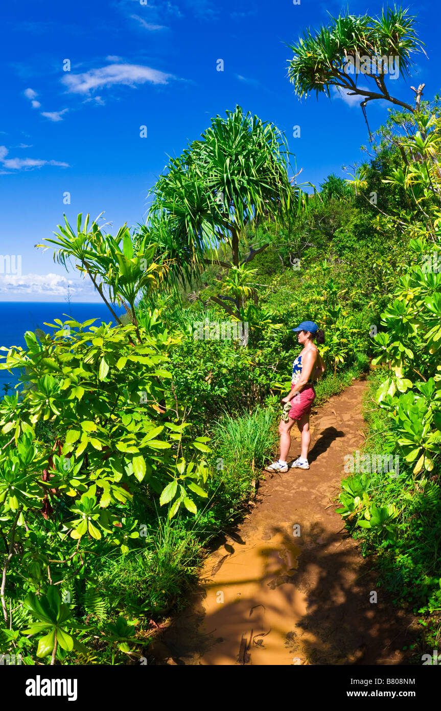 Escursionista sul lussureggiante Kalalau Trail sulla costa di Na Pali Isola di Kauai Hawaii Foto Stock