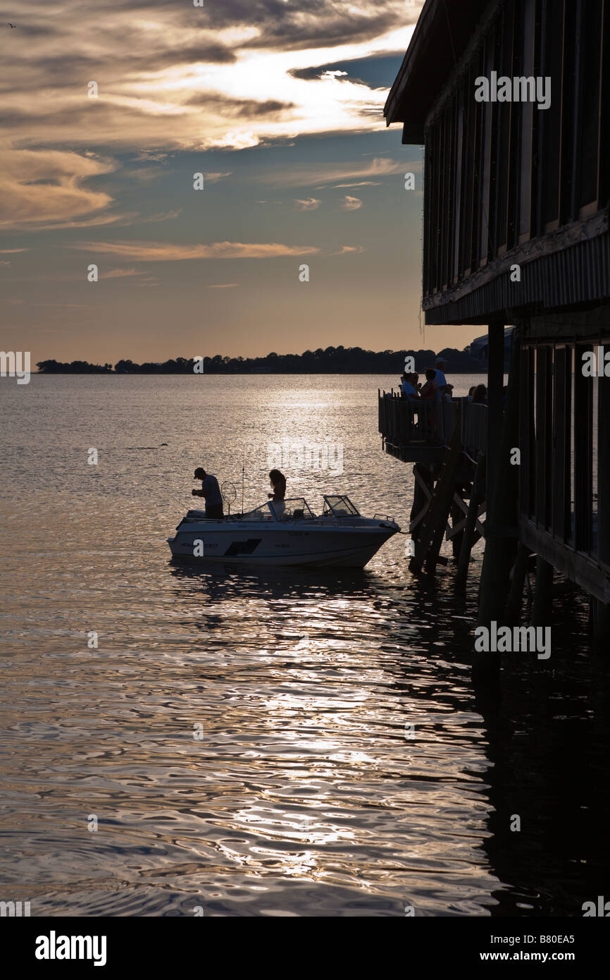 Giovane rigging linee di pesca in barca al tramonto Foto Stock
