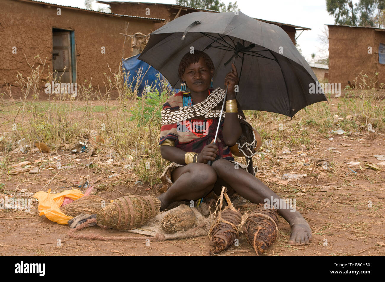 Aari donna sotto un ombrello la vendita di cibo locale, valle dell'Omo,l'Etiopia in Africa Foto Stock
