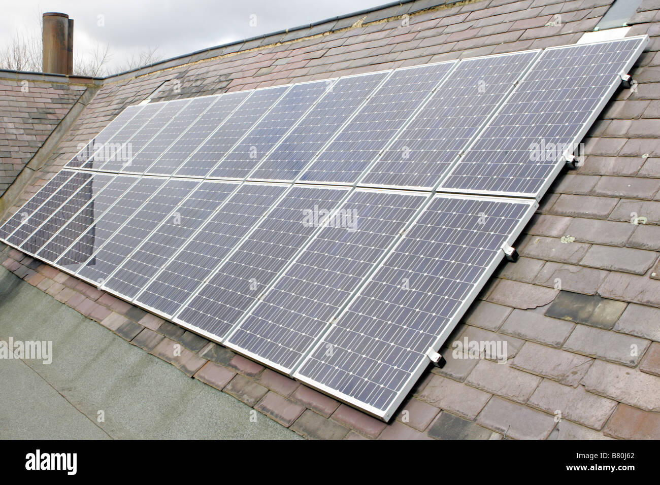 PV solare (fotovoltaica) pannelli su un tetto della scuola per la produzione di energia elettrica. Foto Stock