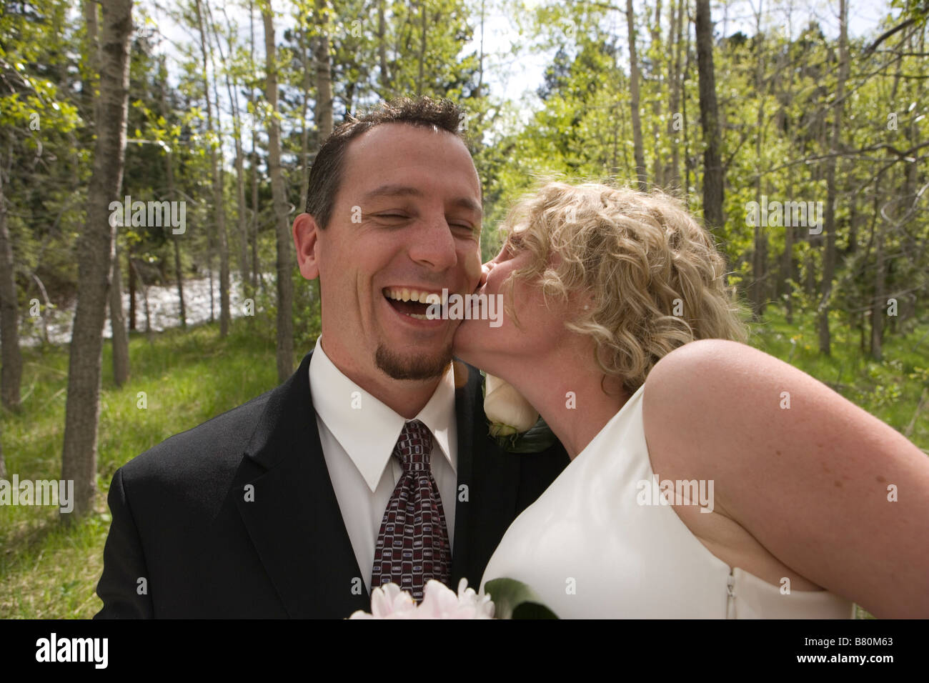 Sposa di baciare lo sposo felice all'aperto, cerimonia di nozze Foto Stock