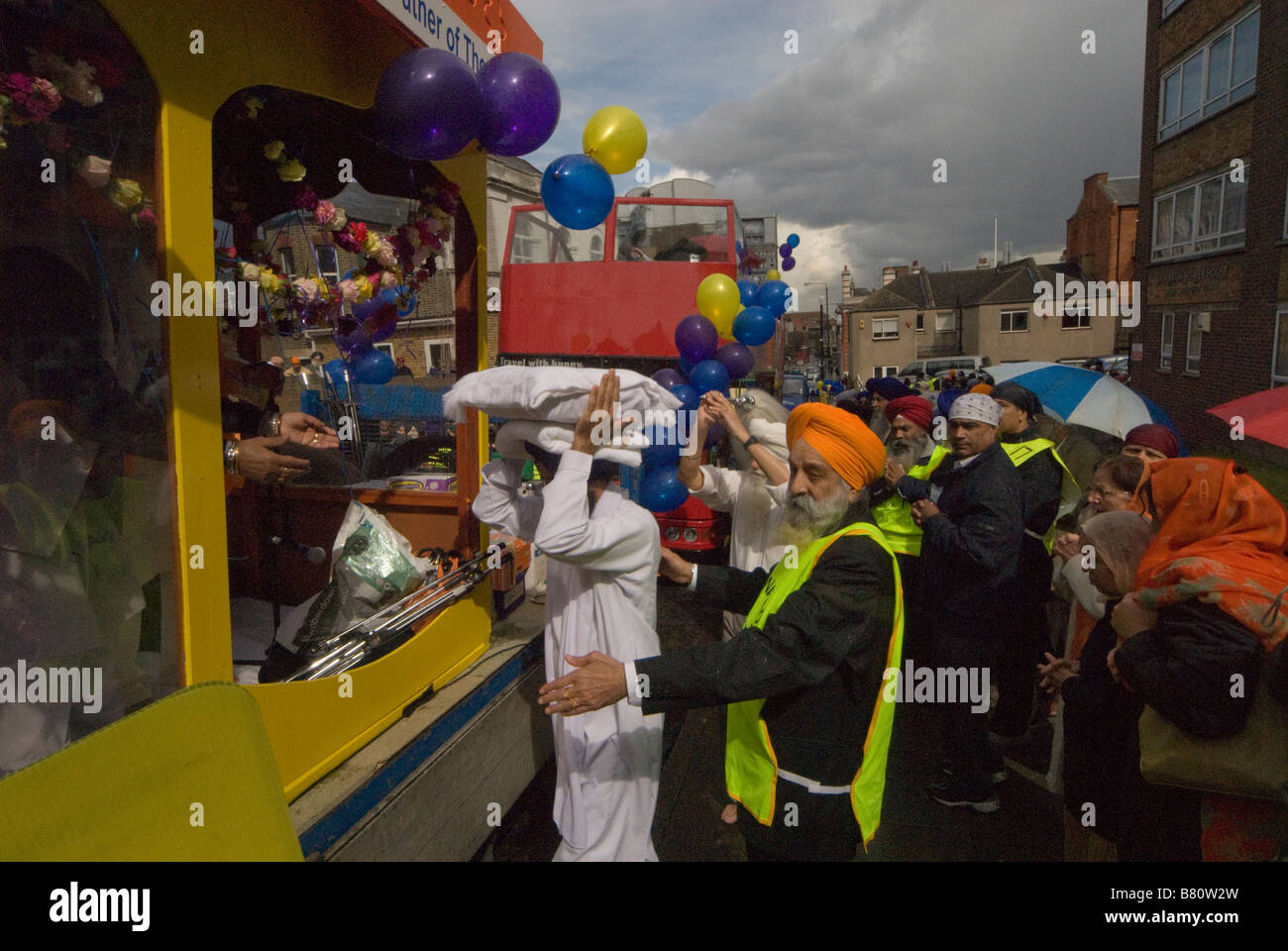 Il Guru Granth Sahib - i sikh libro sacro viene effettuata su un uomo di testa per il galleggiante per la processione Vaisakhi Foto Stock