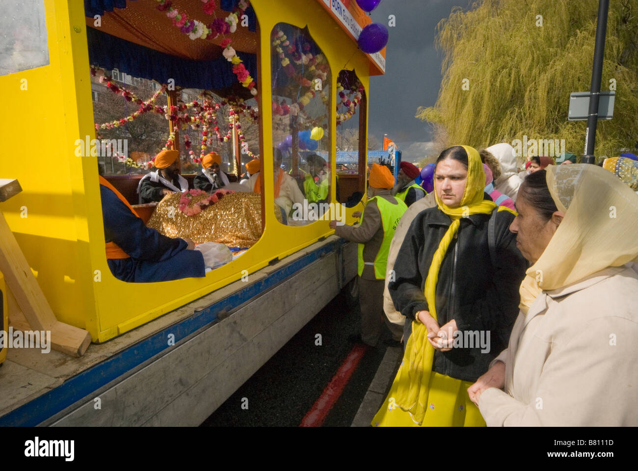 Le donne a piedi dal galleggiante portante il Guru Granth Sahib in processione Vaisakhi a Woolwich, Londra Aprile 2008 Foto Stock