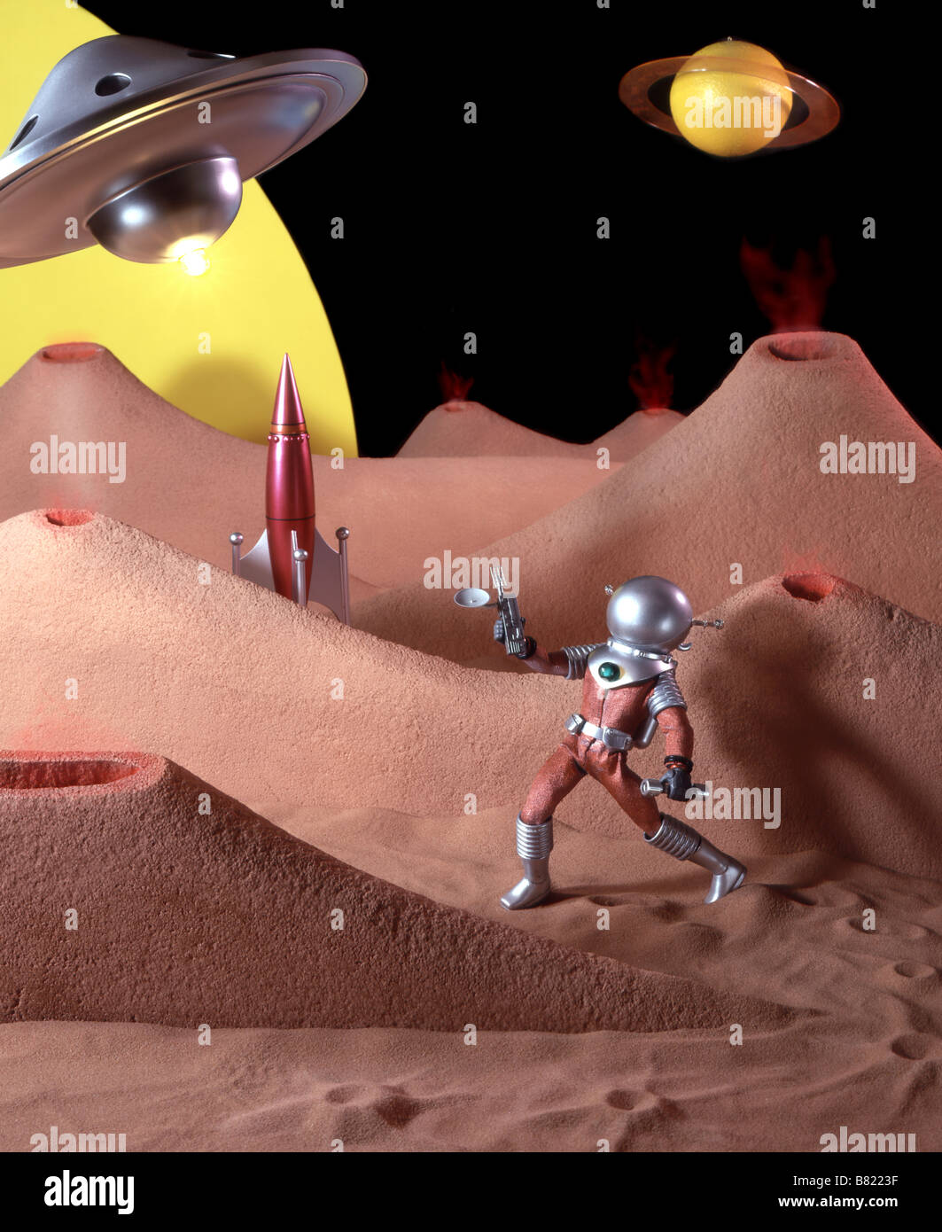 Il kitsch 50's Science Fiction film impostato con Toy Spaceman e pianeti. Foto Stock