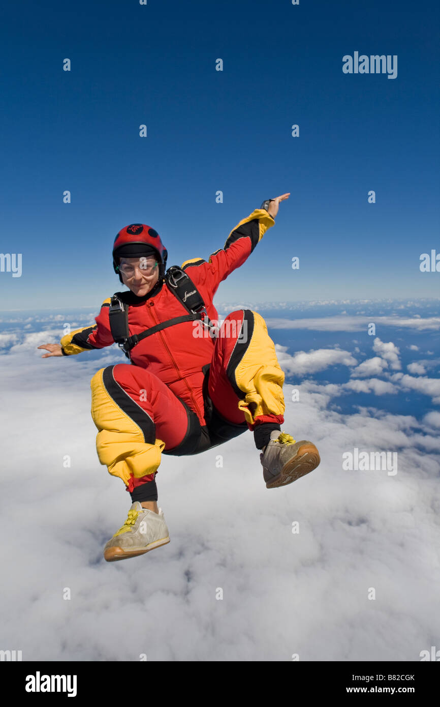 Paracadutista è sedersi volare nel cielo blu su una grande nuvola e divertirsi. La linea di riva nella parte posteriore è come riferimento per immersione. Foto Stock