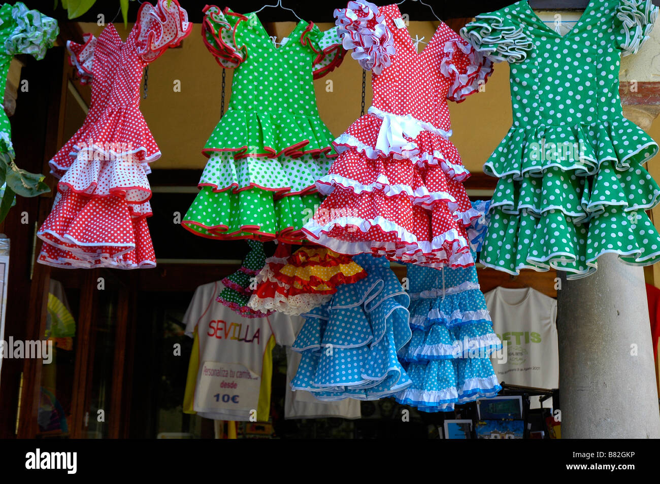 Bambini tradizionali abiti di flamenco visualizzati al di fuori del negozio, Siviglia, Spagna. Foto Stock