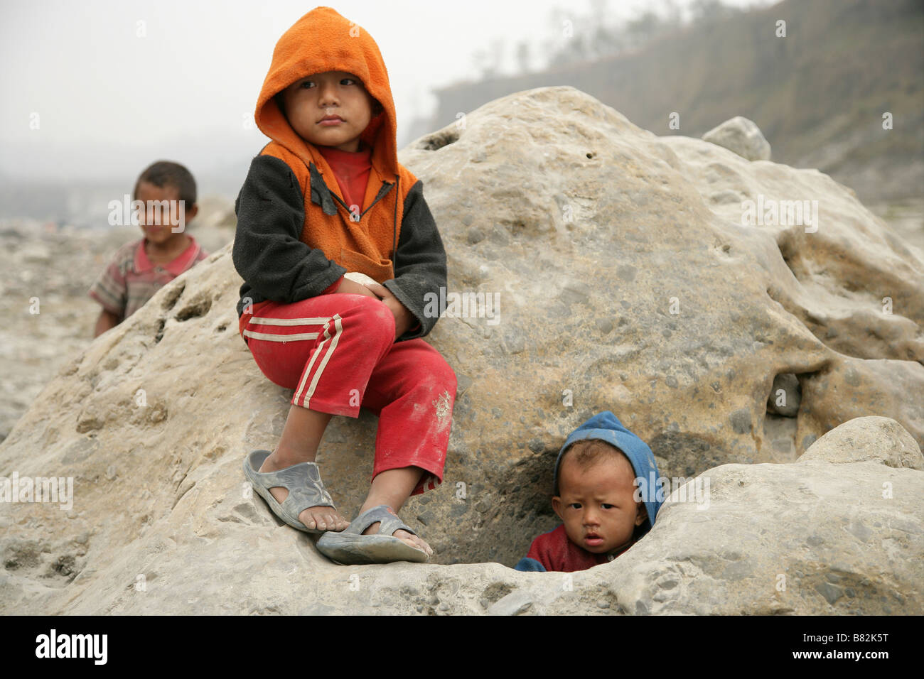Bambini nepalesi seduto su una grande roccia Foto Stock