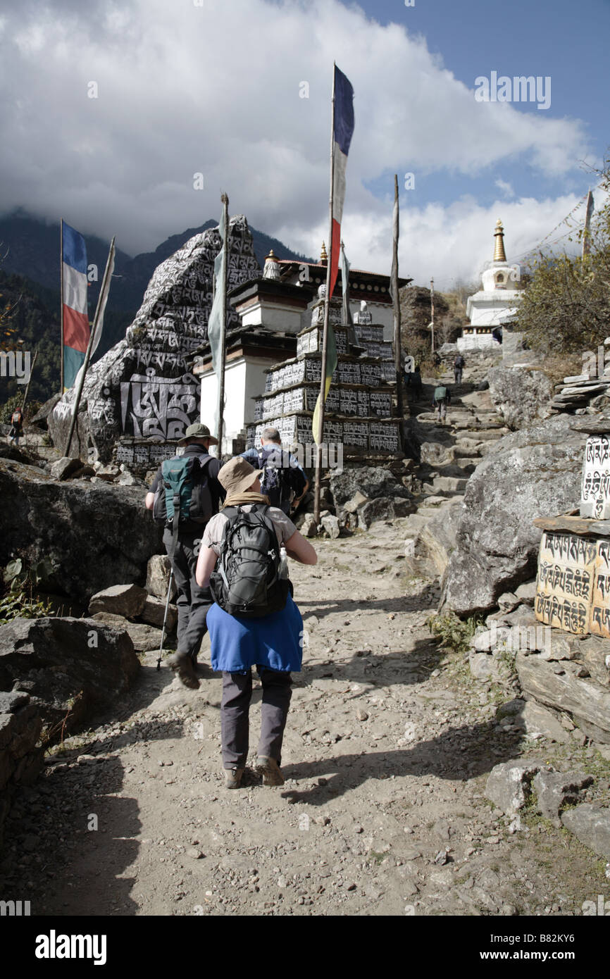 Trekking a piedi passato preghiera pietre in Nepal Foto Stock