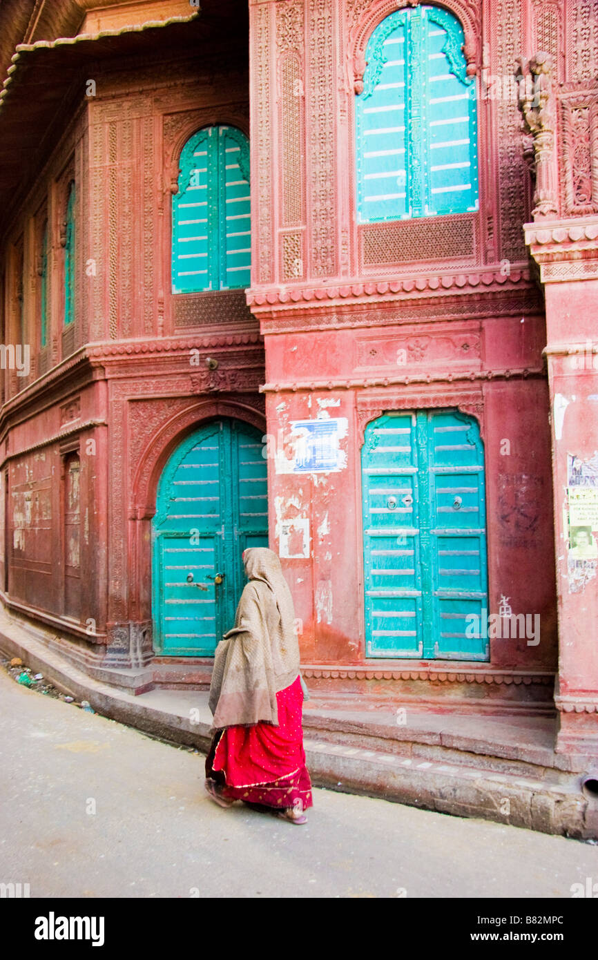 Donna cammina passato esterno di un Haveli Bikaner Rajasthan in India Foto Stock