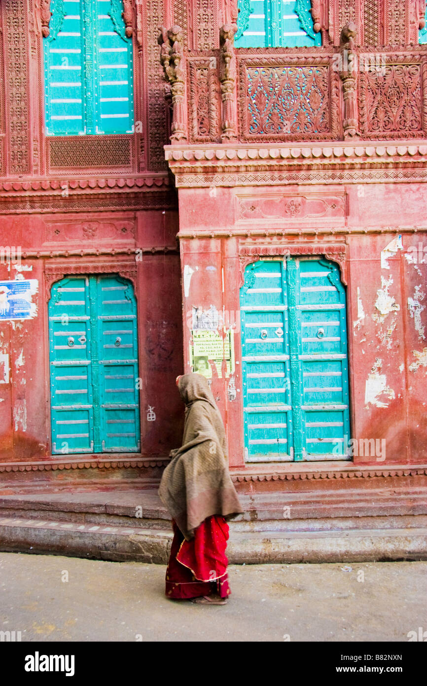 Donna cammina passato esterno di un Haveli Bikaner Rajasthan in India Foto Stock