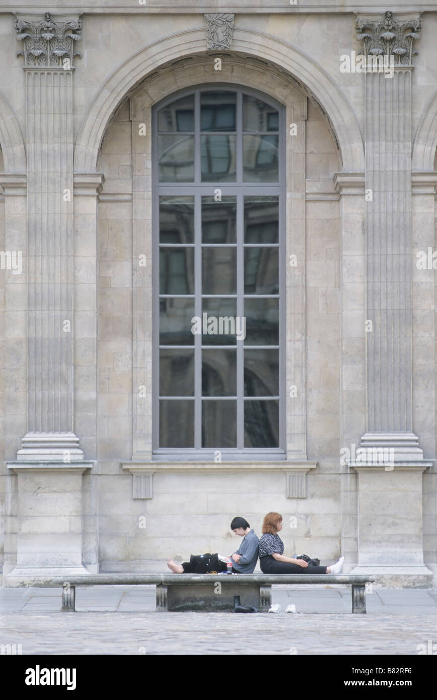 Giovane resto sulla panchina nel cortile del Louvre, Parigi Francia, Carree Louvre, il Musee du Louvre, la lettura, la storia e la cultura francese. Foto Stock