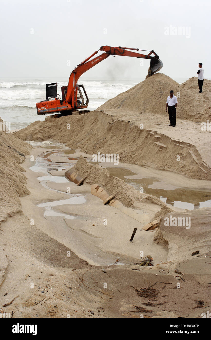 Un escavatore lavorando sulla spiaggia sabbiosa a Kuala Terengganu, Malaysia. Foto Stock