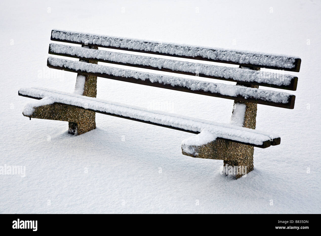 Lone una panchina nel parco sulla neve Foto Stock