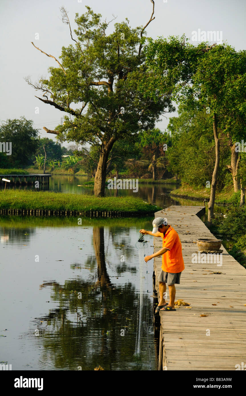 La pesca lungo un canale a Bangkok in Tailandia Foto Stock