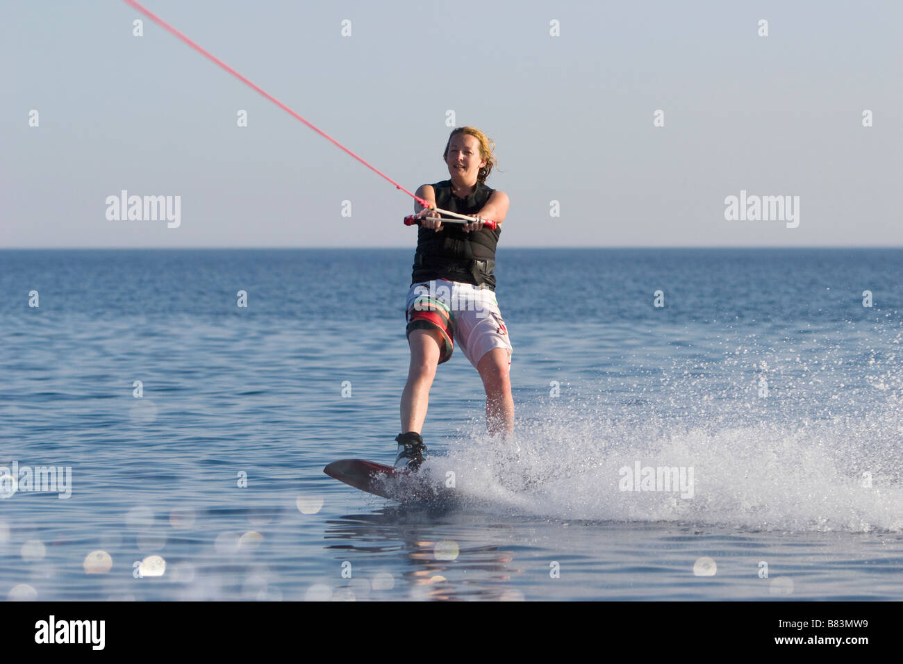 Un wakeboarder gode dell'acqua piatta durante il traino dietro una barca a motore in Laguna Bay nel Sinai resort di Dahab in Egitto Foto Stock