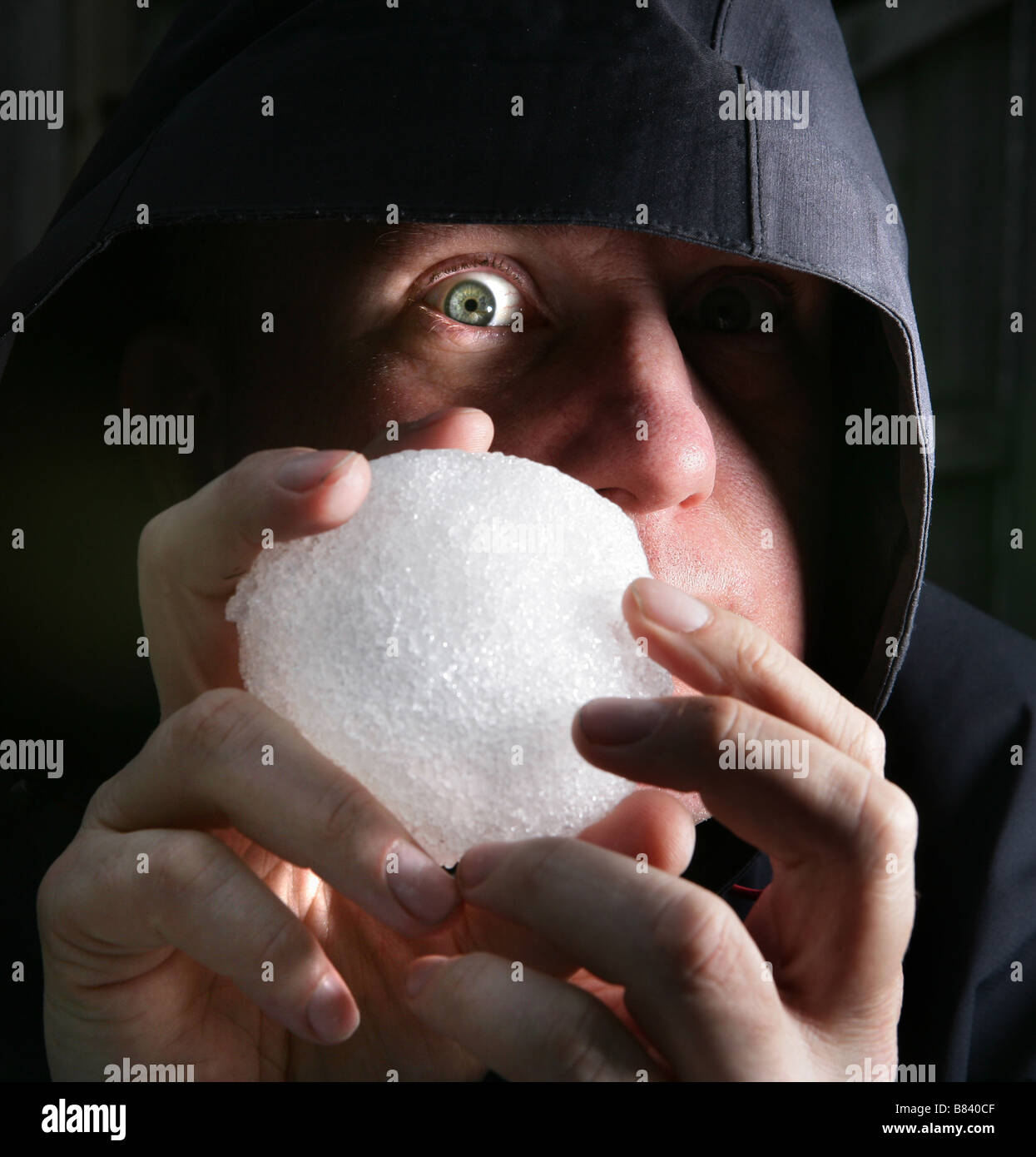 Un uomo tiene una palla di neve come ha intenzione di buttare a sua vittima Foto Stock