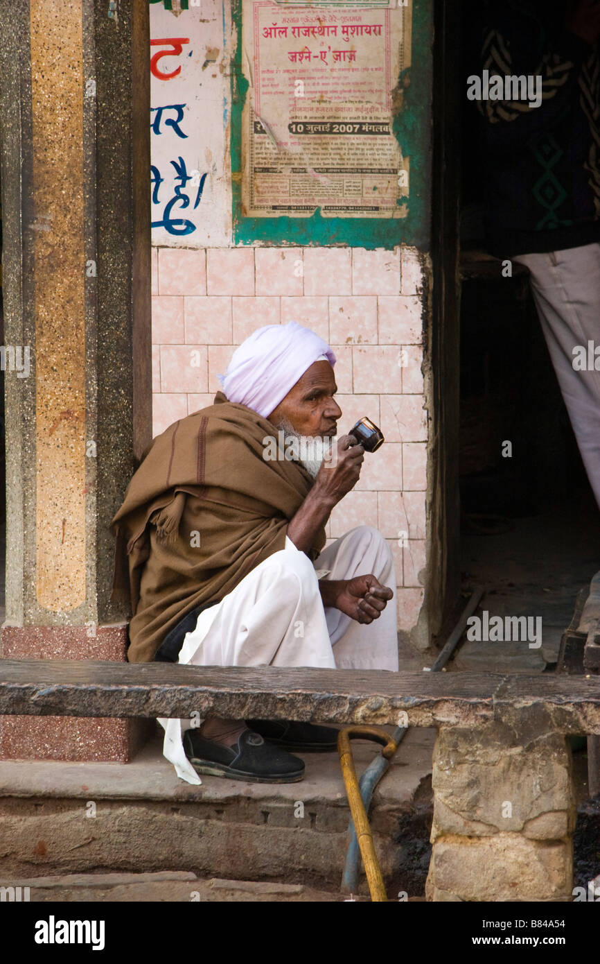 Uomo locale bevande tè seduta Bikaner Rajasthan in India Foto Stock