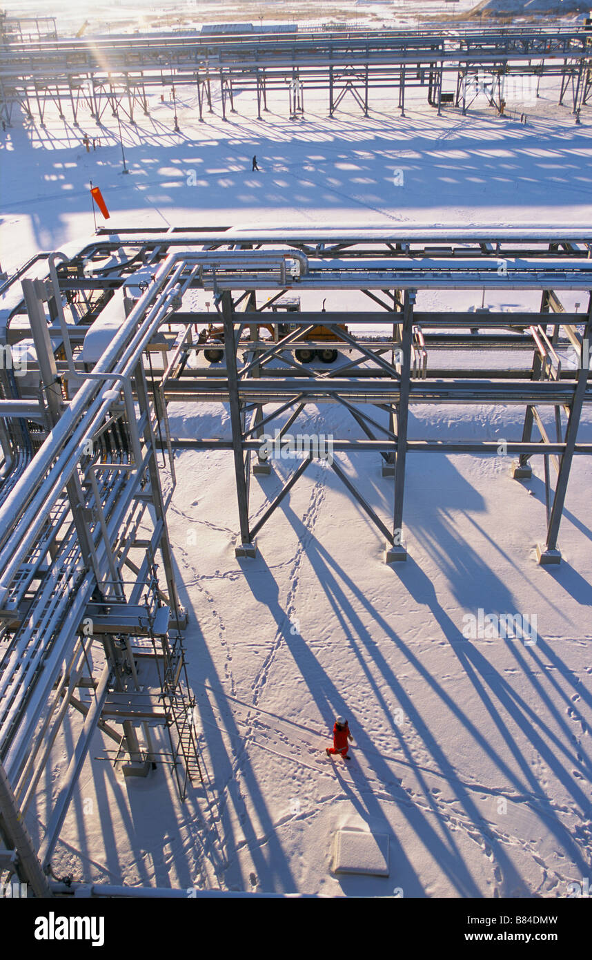 In inverno profondo di 20 gradi C un operatore cammina tra le tubazioni ad un impianto di olio Kazakistan Foto Stock