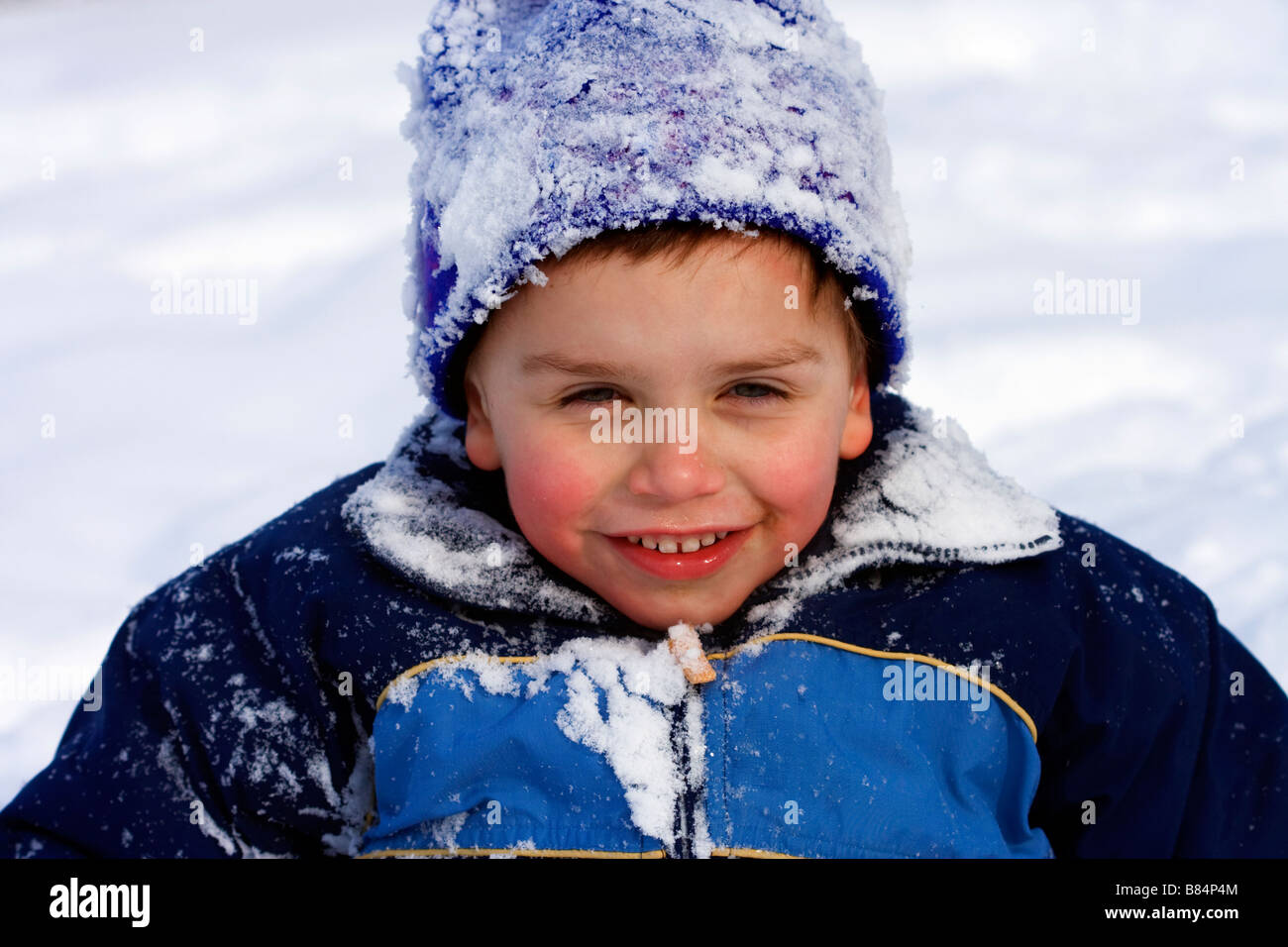 Un giovane ragazzo in una coperta di neve toque avente il divertimento sulla neve a Calgary, Alberta, Canada. Foto Stock