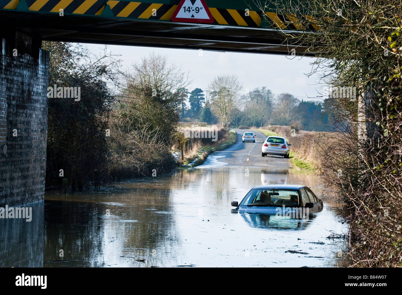 Auto subacquea proprietario dopo aver guidato sotto il ponte in profonda alluvione Foto Stock