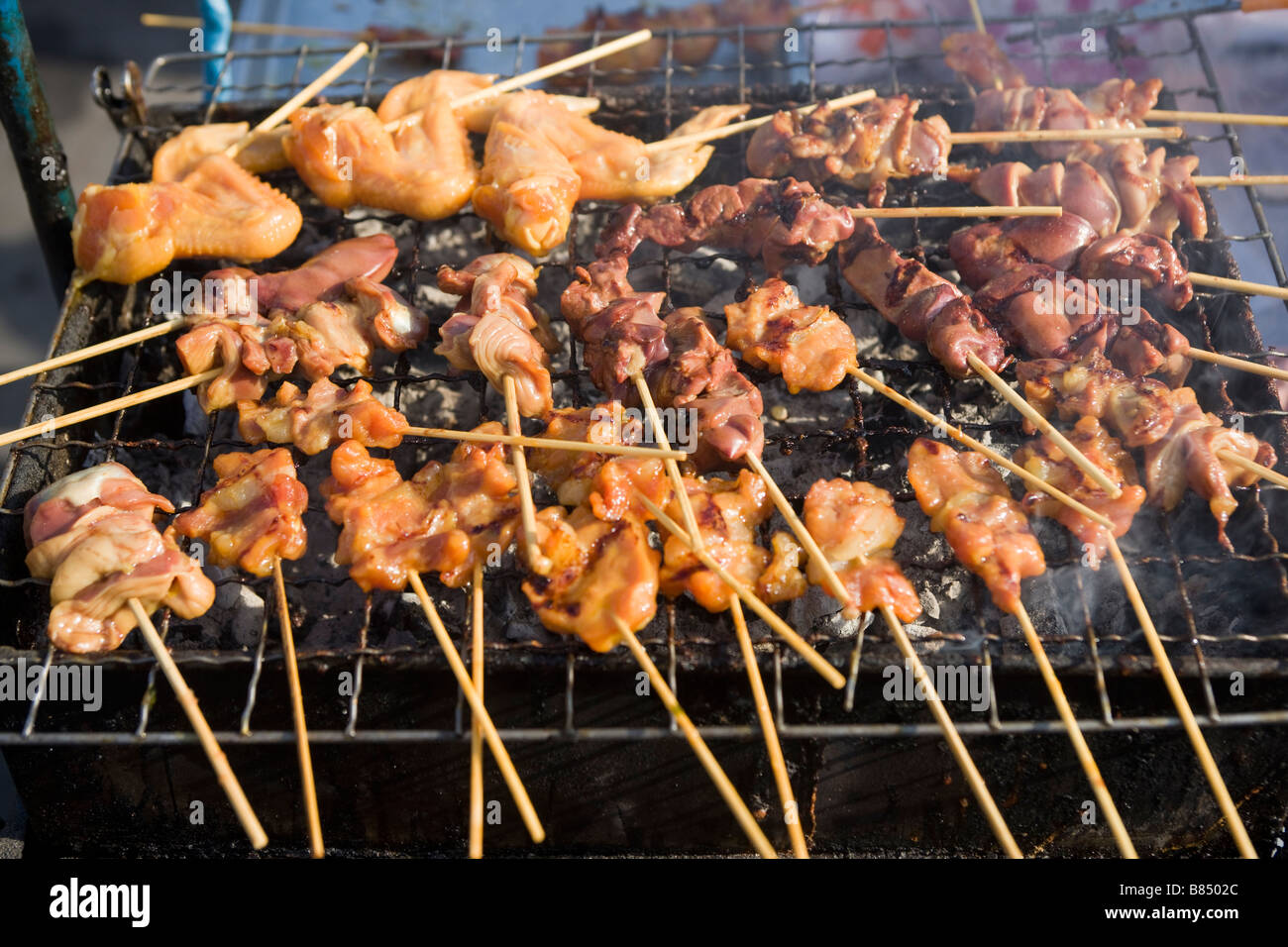 Cottura del pollo alla griglia, Mercato del fine settimana di Chatuchak Bangkok in Thailandia Foto Stock