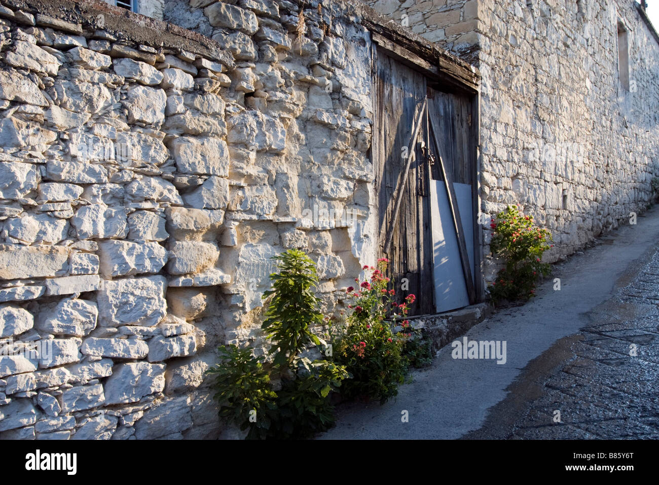 Casa di mattoni a parete con porte chiuse nel villaggio di Omodhos, monti Troodos, Cipro del Sud Foto Stock