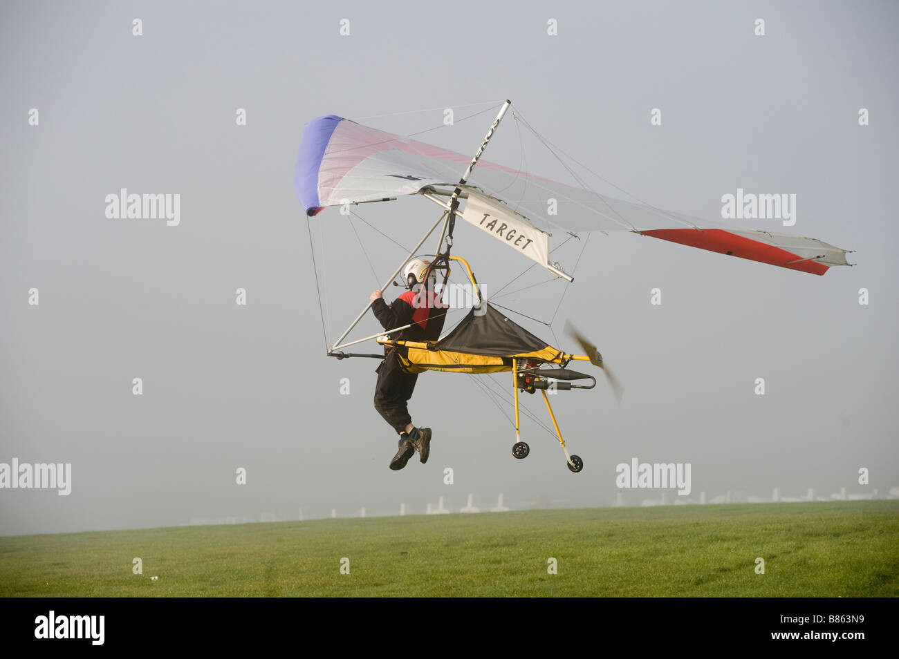 Sbarco pilota in un motore alimentato hanglider Foto Stock