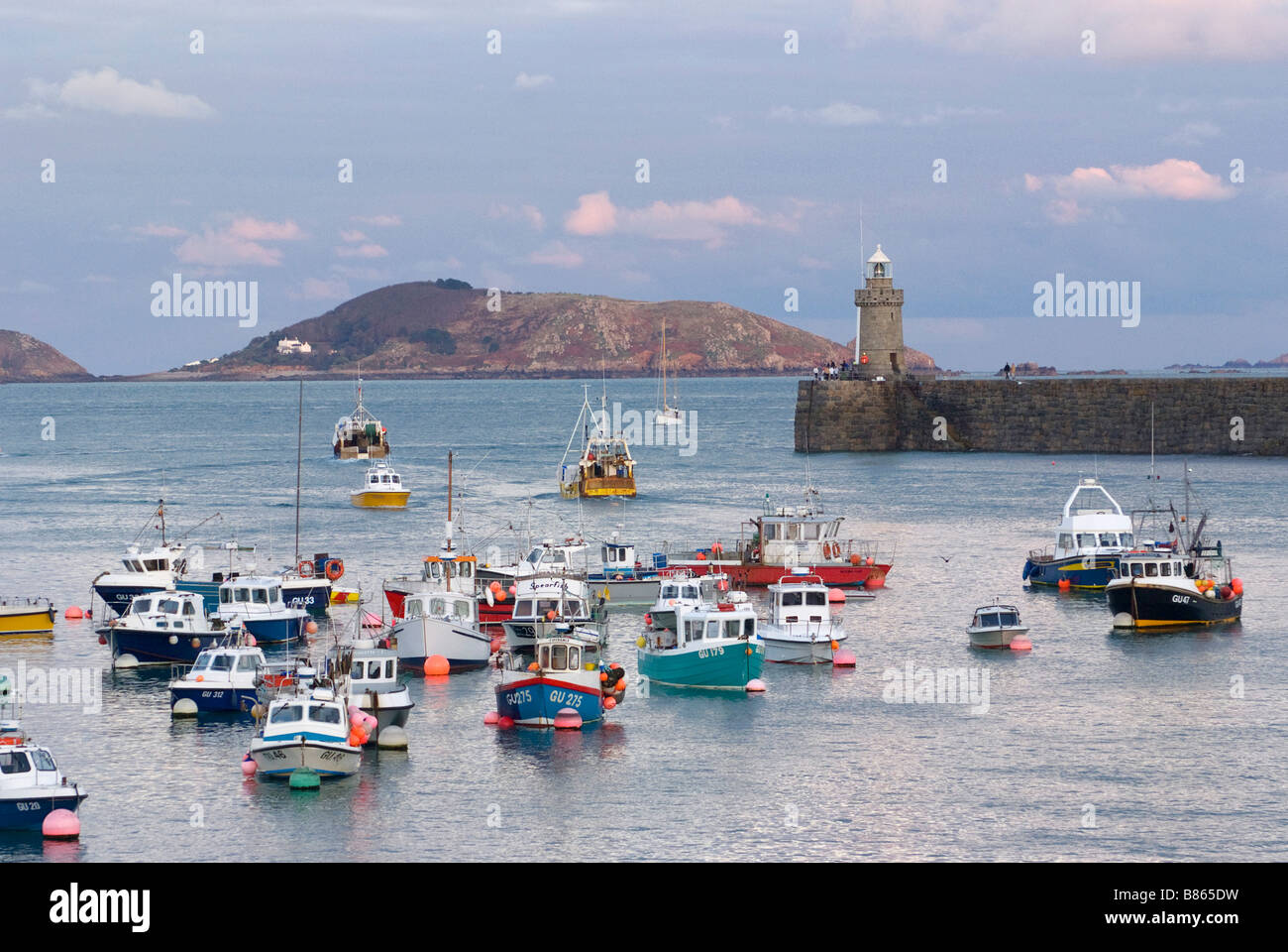 Faro sulla scogliera e le barche nel porto, St Peter Port Guernsey Foto Stock