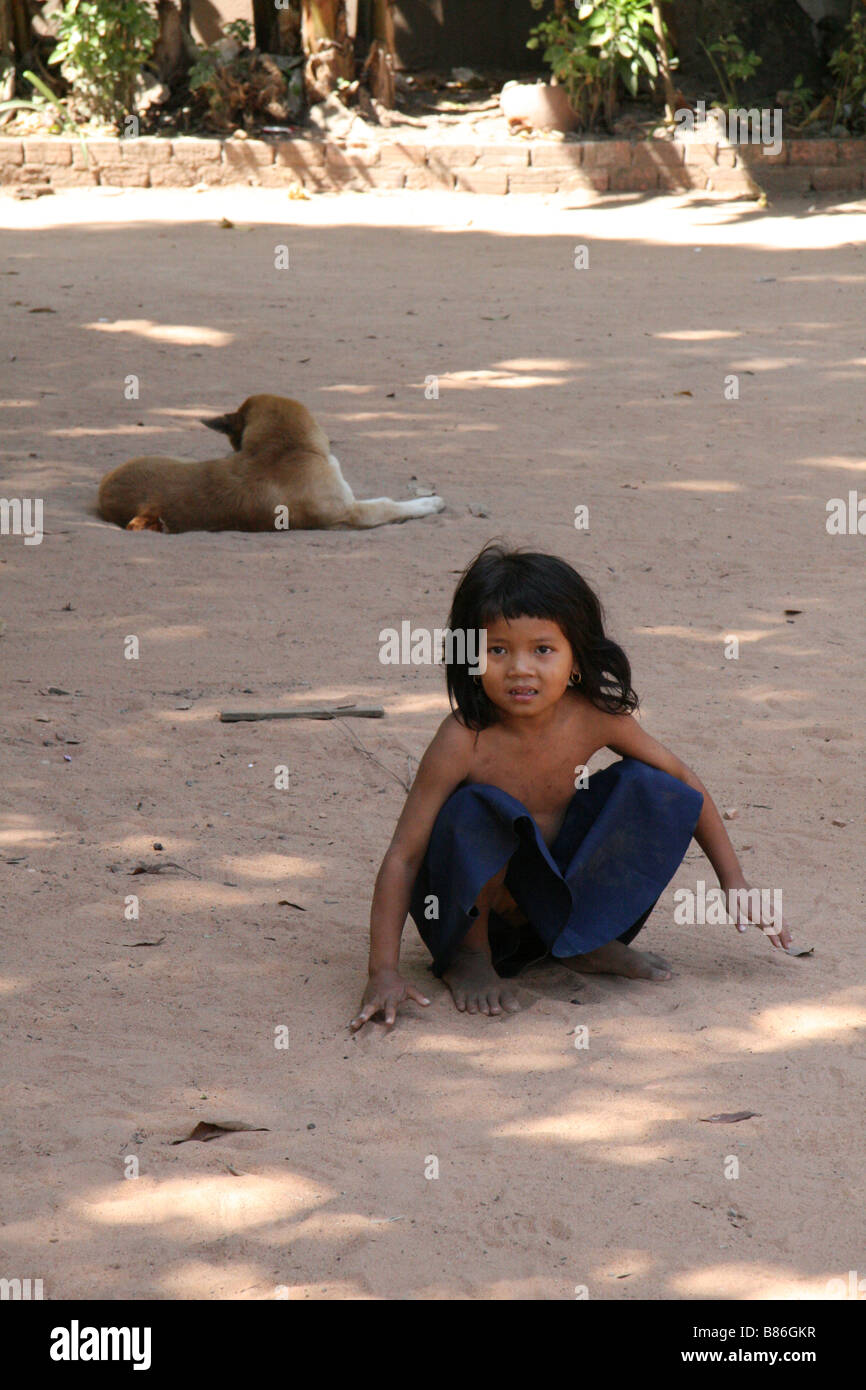 Fotografia di una bella ragazza cambogiano e cane giocando nei pressi di un tempio in Siem Reap Foto Stock