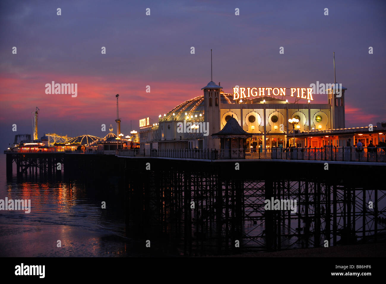 Il Brighton Pier al tramonto con la vita notturna solo all'inizio. Foto da Jim Holden. Foto Stock