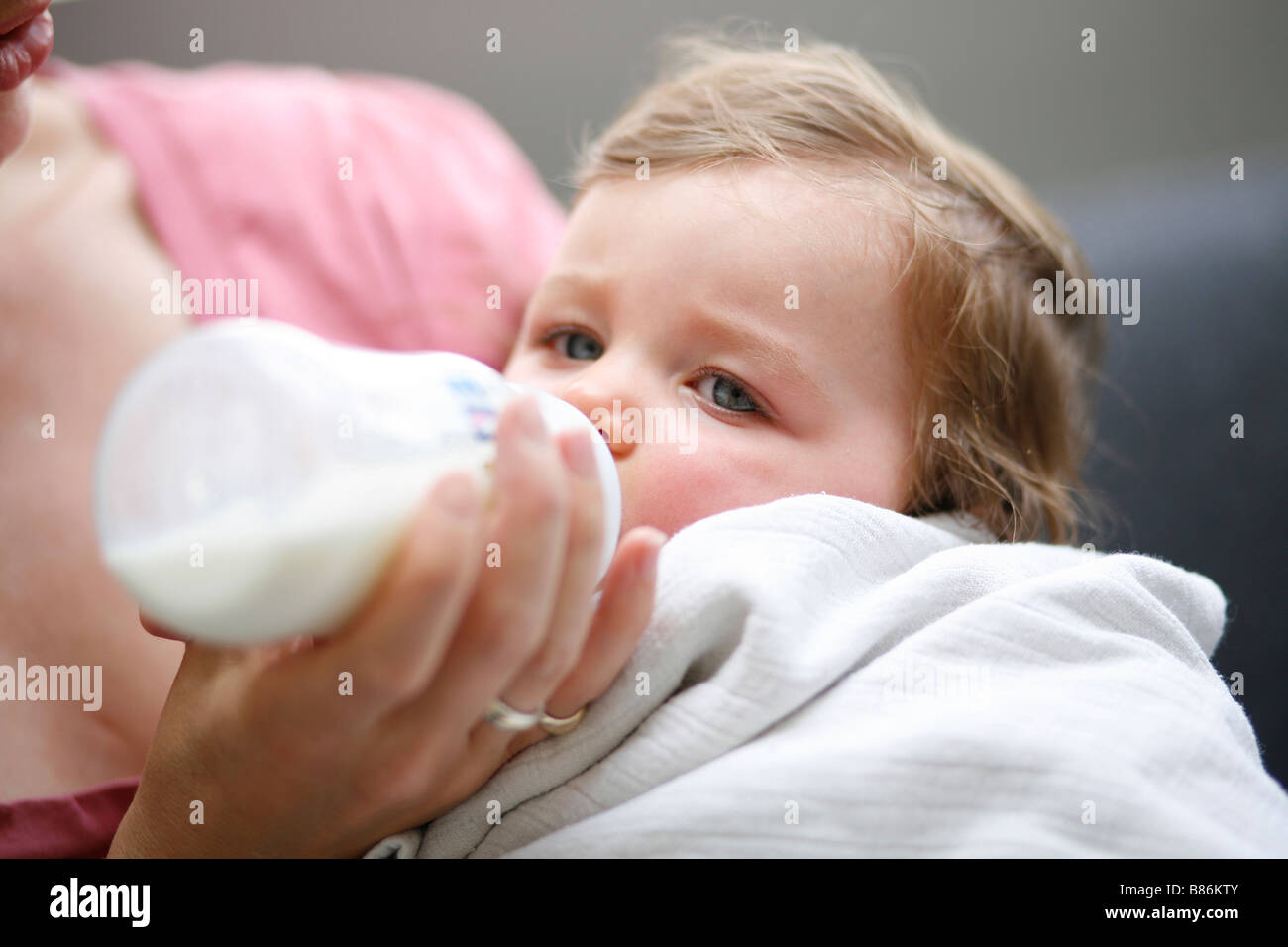 Una bambina bottiglia è alimentato da sua madre Foto Stock