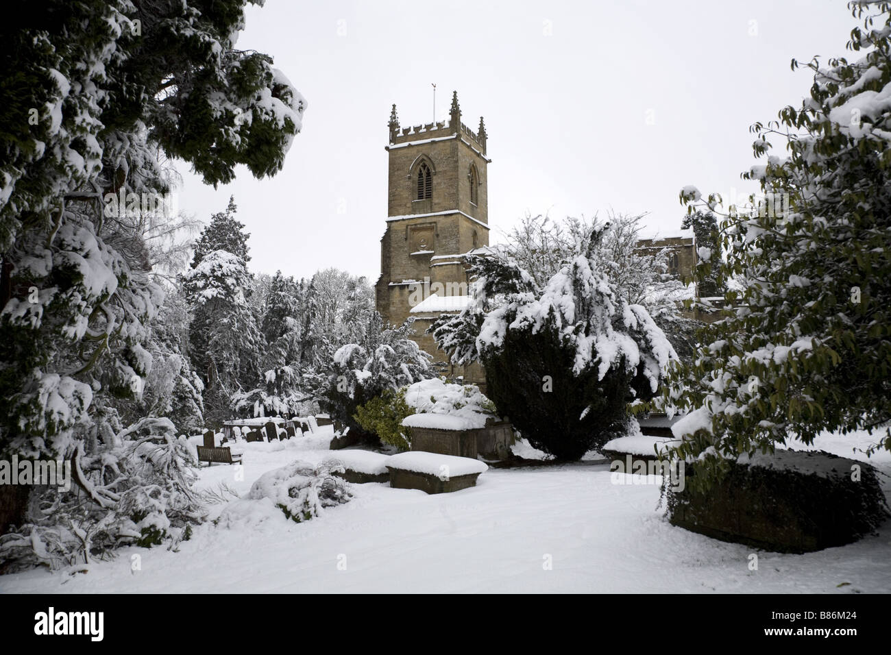 Coperta di neve chiesa e cimitero in Oxfordshire. Foto Stock