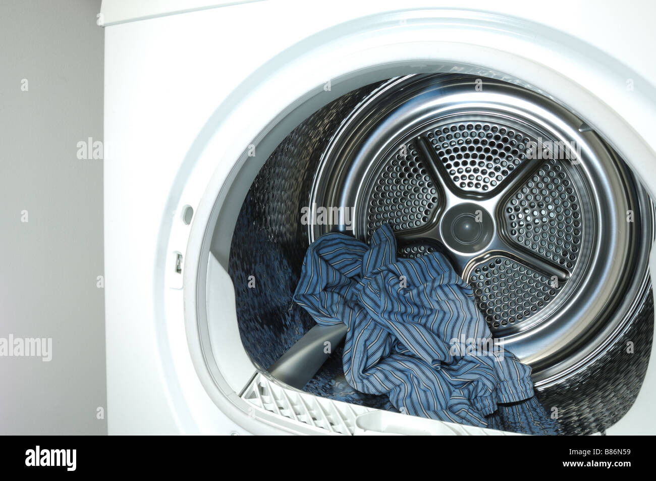 Pantaloni blu all'interno di una macchina lavabiancheria asciugatura Foto Stock