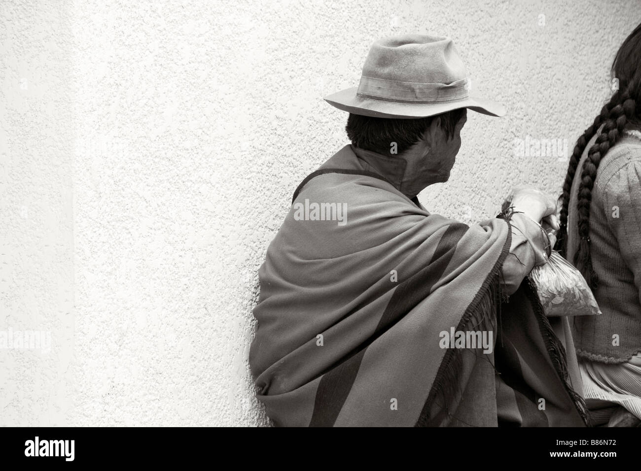 La popolazione locale seduta in strada Tarabuco Bolivia il verde sacchetto di plastica nell'uomo s mano contiene la foglia di coca Foto Stock