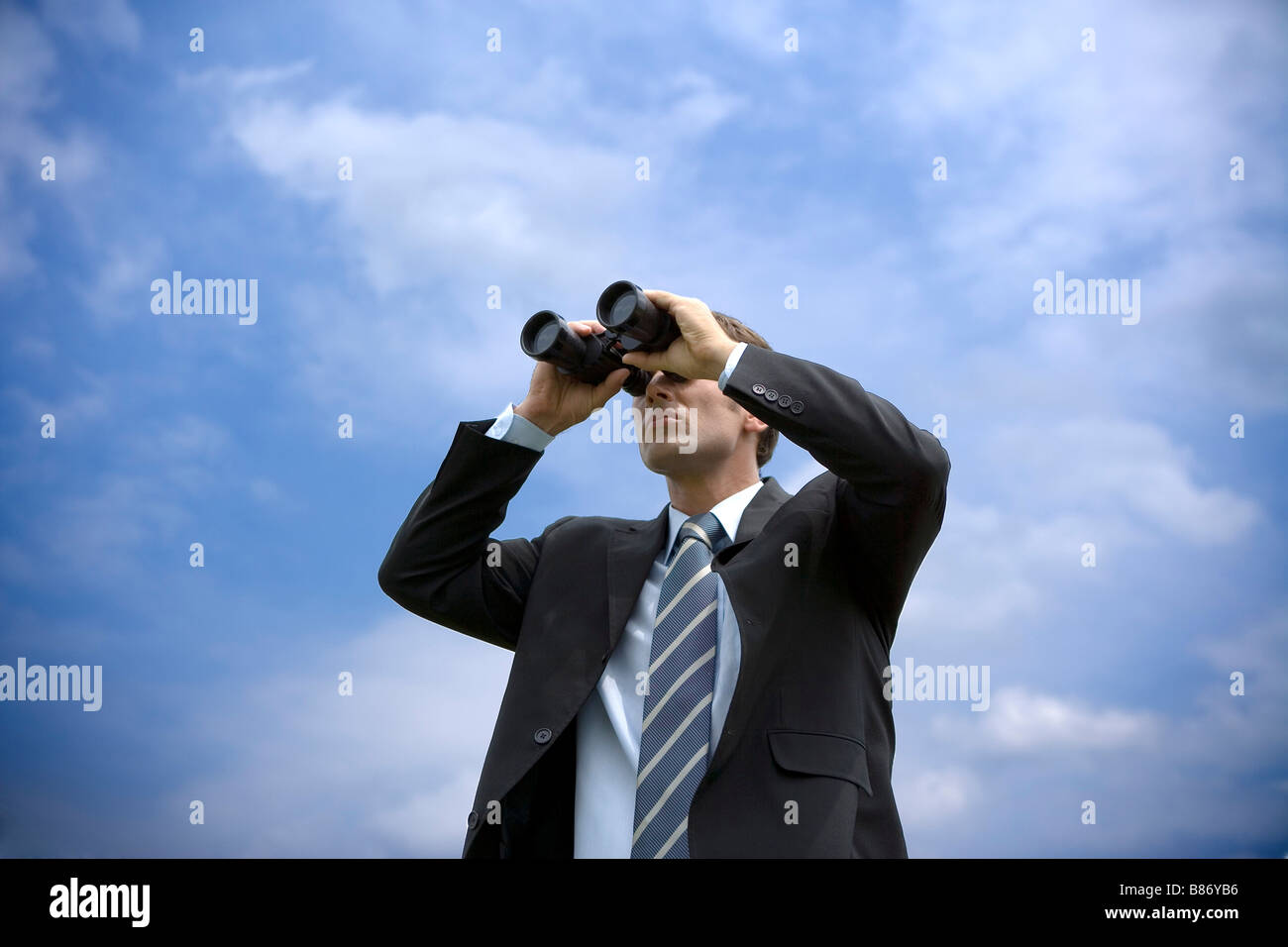 Imprenditore utilizzando il binocolo vista dal basso Foto Stock