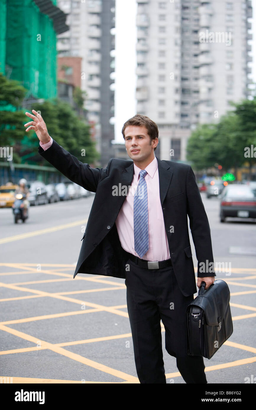 Imprenditore salutando taxi Foto Stock