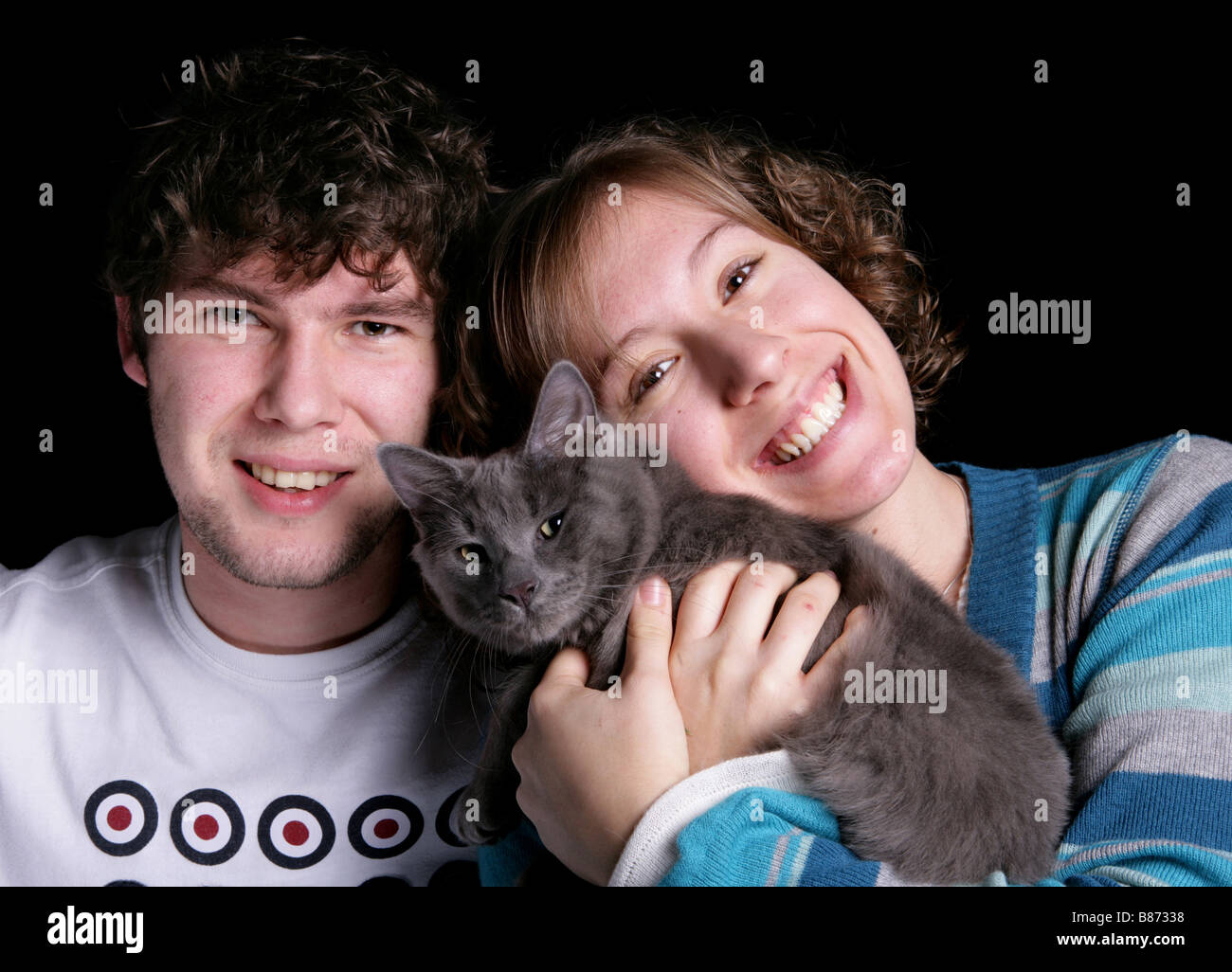 Due persone con un gatto adulto maschio e femmina adulta con un gatto grigio studio Foto Stock