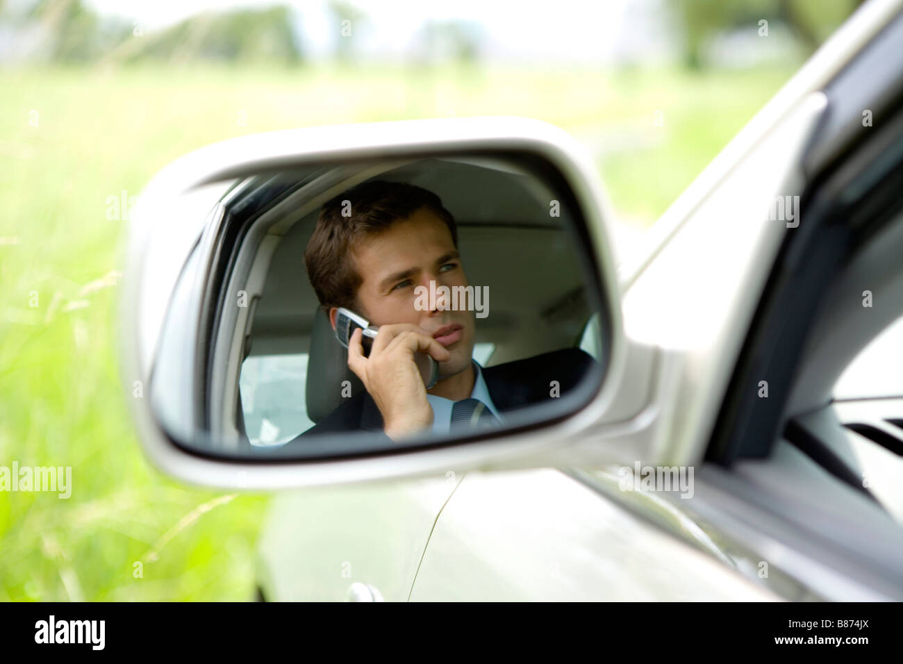 Imprenditore seduti in auto utilizzando il telefono cellulare Foto Stock