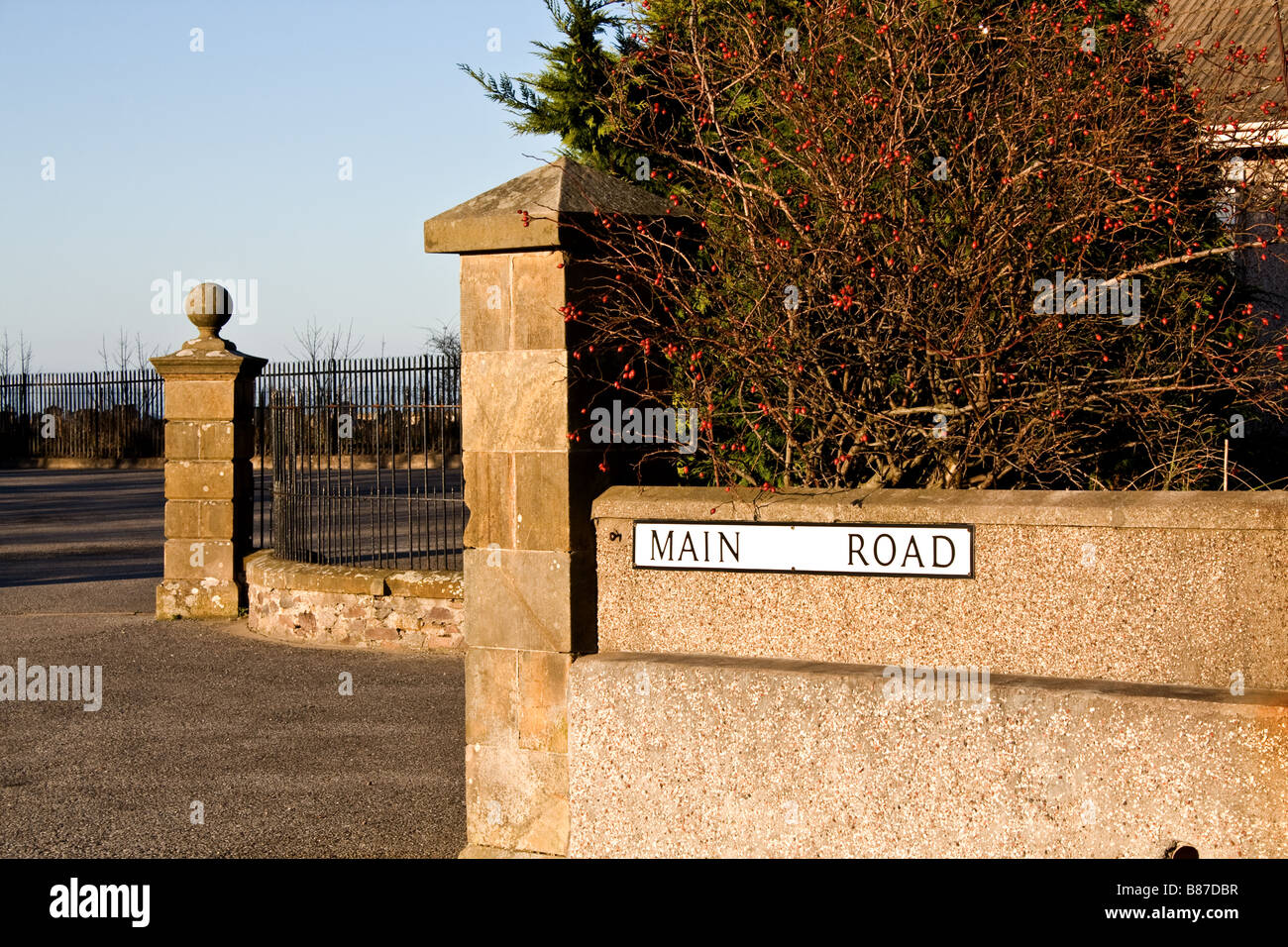 'Main Road' segno su un muro di pietra in Rathven, Scozia Foto Stock