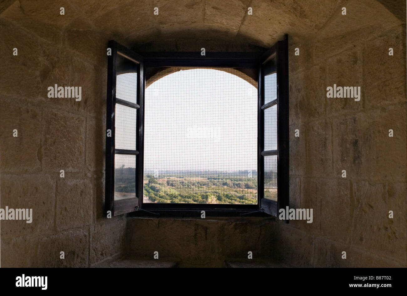 Vista sulle colline e paesaggio di Kolossi attraverso il castello finestra sul tramonto a Cipro del Sud Foto Stock