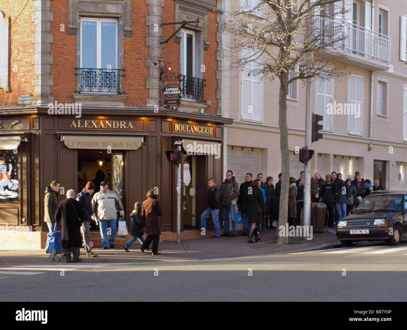 Il giorno di Natale al di fuori della coda Boulangerie Alexandra una panetteria popolare nei sobborghi di Parigi Foto Stock